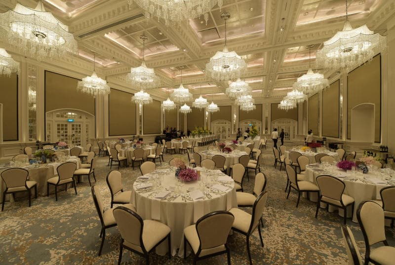 Tables de banquet rondes dressées dans une salle de réception à lustres