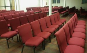Rangées de chaises d’église empilables reliées dans un sanctuaire